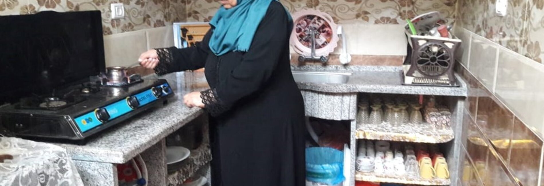 Ibtisam preparing coffee in her new kitchen