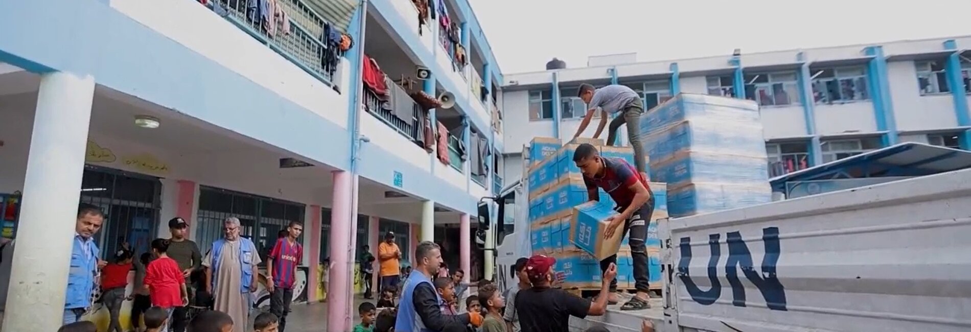 Aid distribution in an UNRWA facility hosting displaced Palestinian families. Screenshot from a video by UNICEF