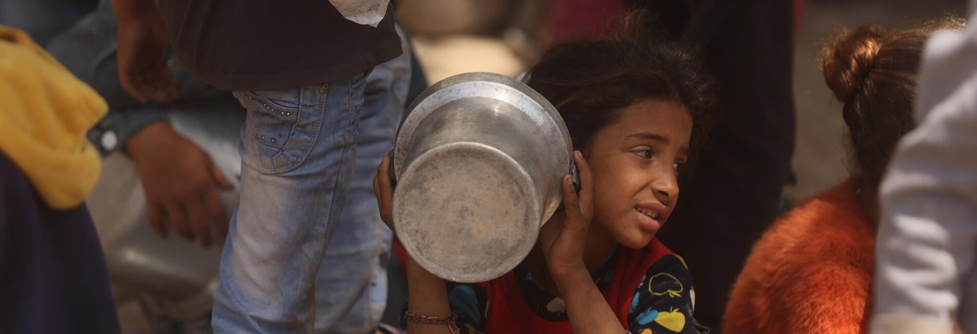 A Palestinian girl waiting for food served by a community kitchen in Gaza city. Photo by UN News