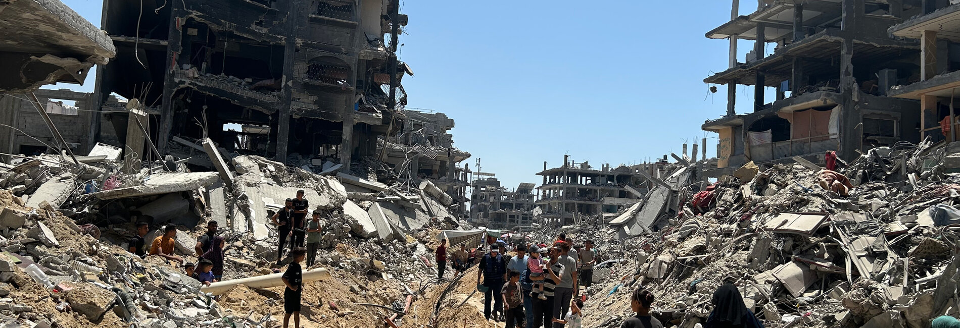 People in a destroyed residential area of Jabalya. Photo by OCHA, 19 June 2024 