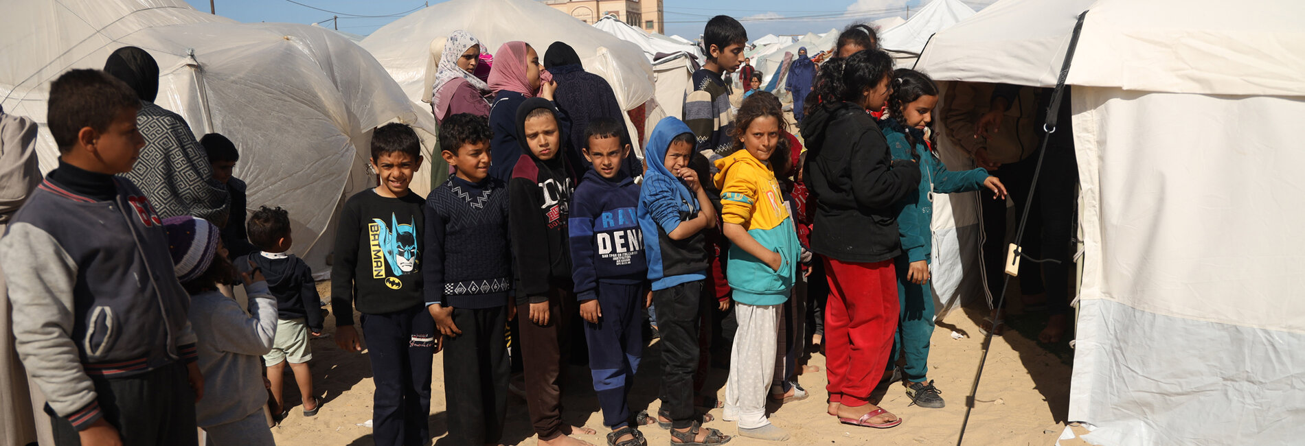 Children standing in line in front of a tent clinic in Rafah, to be screened for malnutrition and referred for treatment as necessary. Photo by UNICEF/El Baba