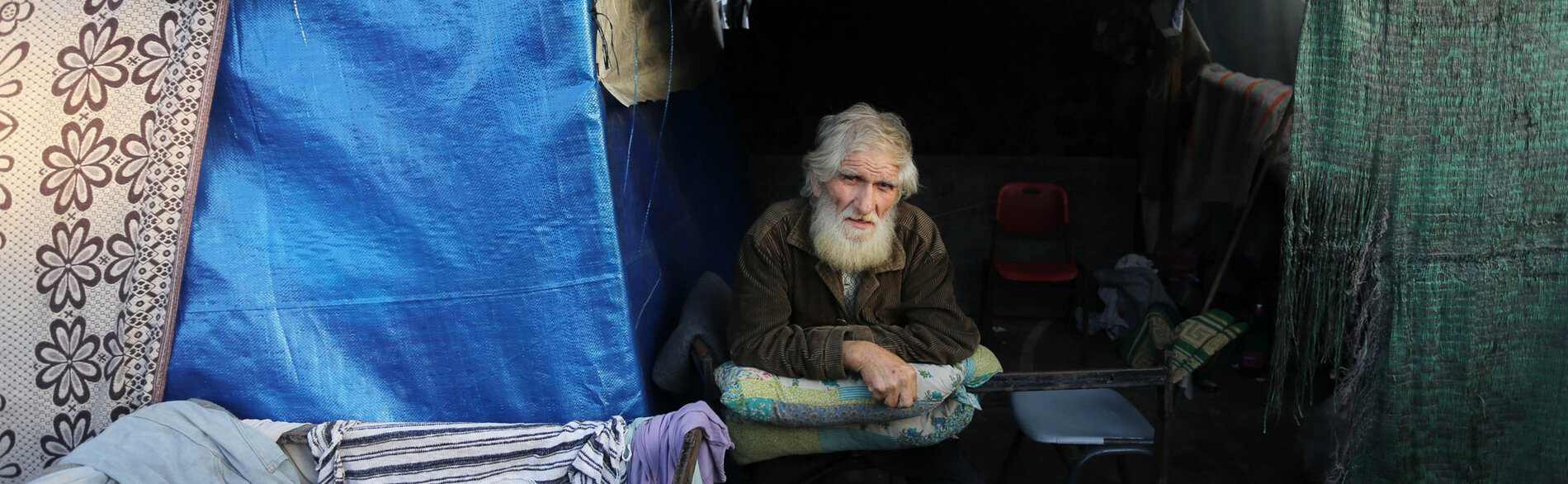 The approximately 111,500 older people in Gaza are among those most at risk of hunger, dehydration, illness, injury, and death, HelpAge reports. A displaced older Palestinian in a makeshift shelter. Photo by UNRWA