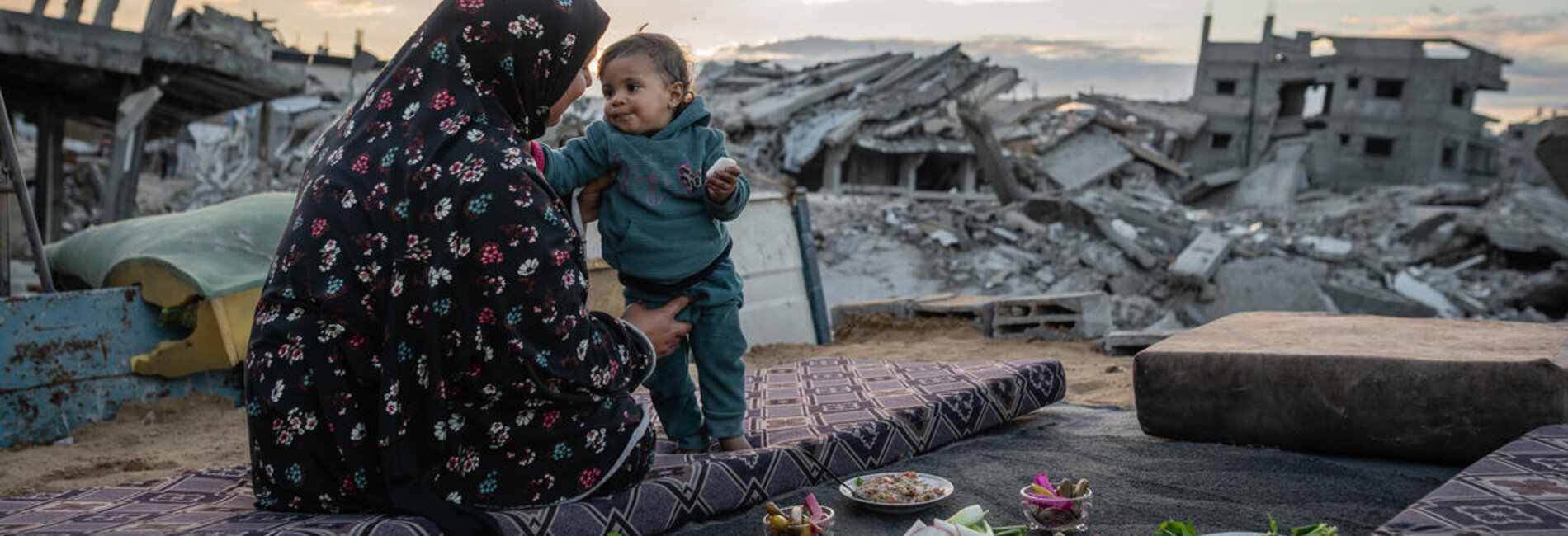 Um Omar, a Palestinian from Gaza, breaking the Ramadan fast out in the open, surrounded by debris. Photo by WFP