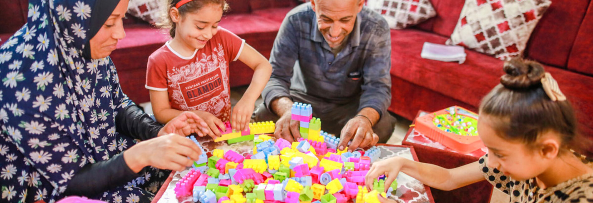 Asma and Sade playing with two of their daughters in their renovated livingroom.