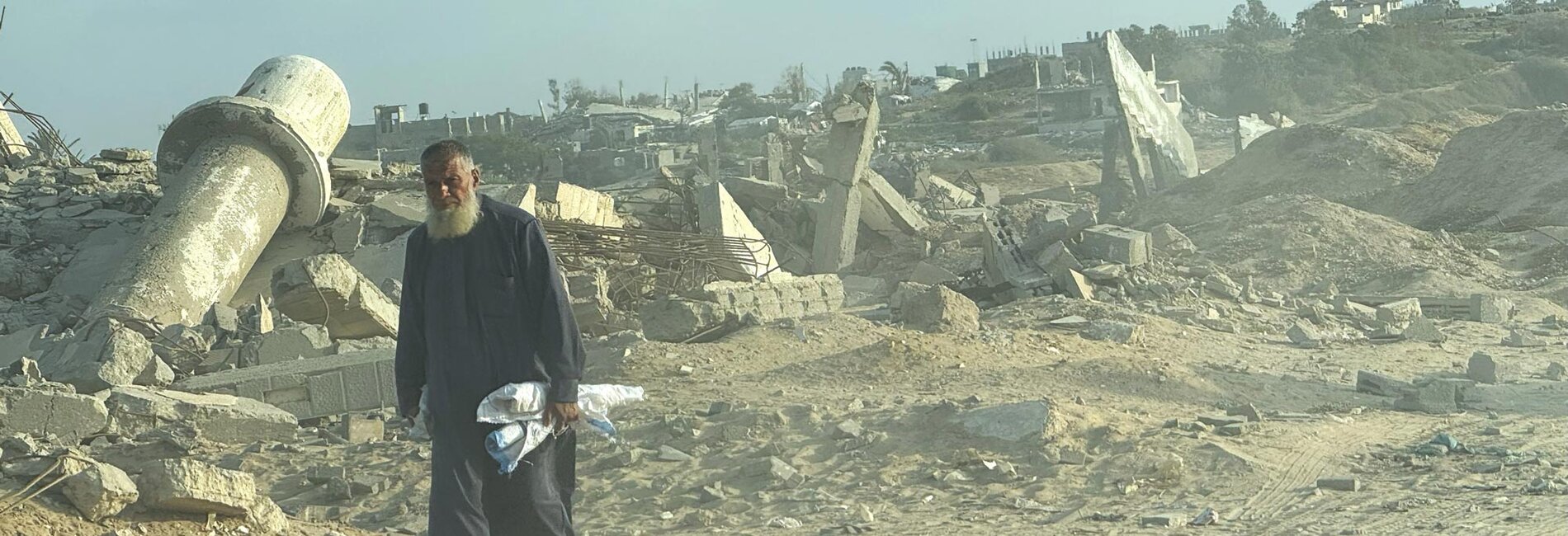A Palestinian man walking through a devastated area of central Gaza. Photo by OCHA/Olga Cherevko