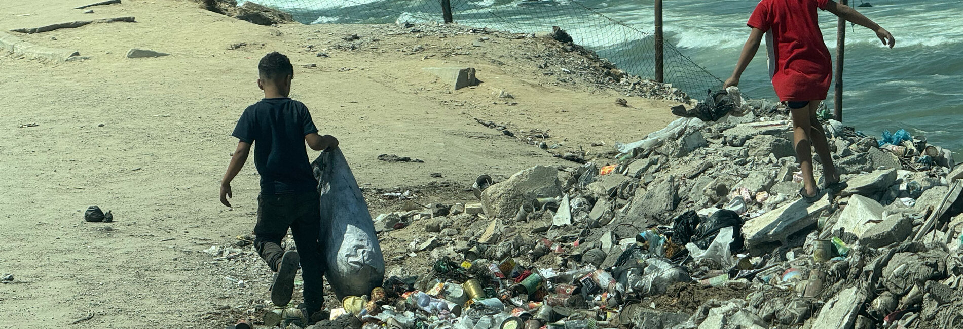 أطفال يبحثون بين المخلّفات على شاطئ غزة. تصوير مكتب الأمم المتحدة لتنسيق الشؤون الإنسانية/أولغا تشيريفكو