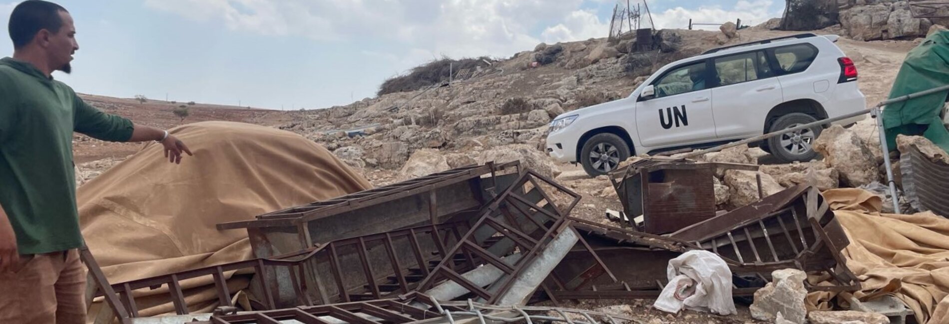 A resident of the Palestinian herding community of Khirbet Tell al Khashaba, in Nablus governorate, showing a UN team what remains of structures that Israeli authorities demolished. Photo by OCHA