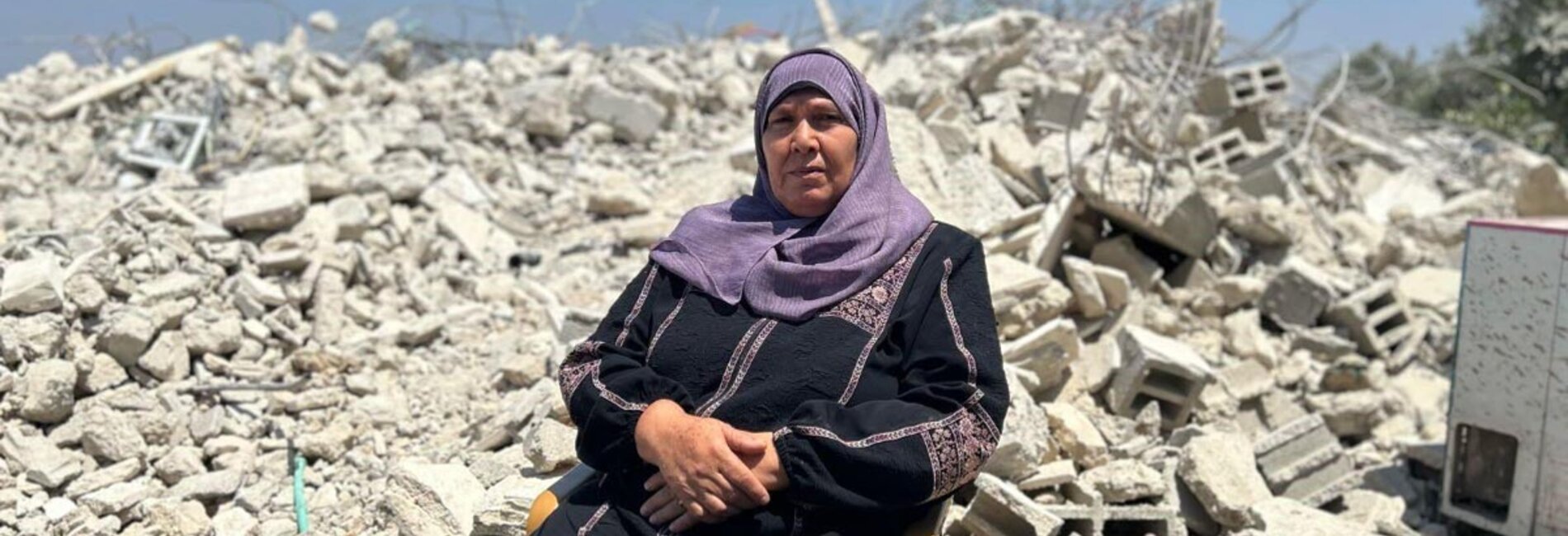 A Palestinian woman sits on the rubble of a building she nearly finished constructing when Israeli forces demolished it in Rafat village, west of Salfit. Photo OCHA.