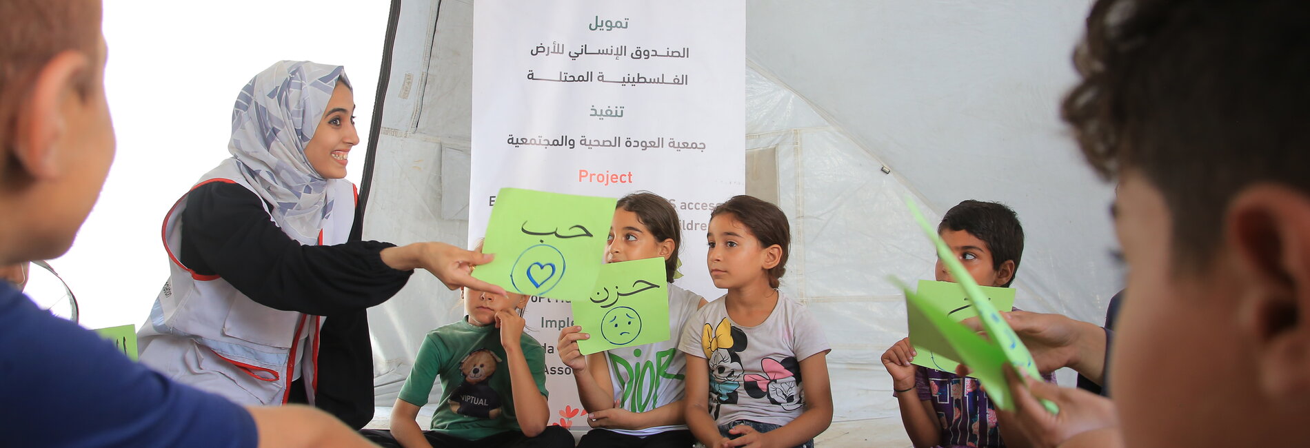 AWDA team member providing psychosocial support to children in Gaza, 2023. Photo by AWDA. (Sara and her children are not pictured.)