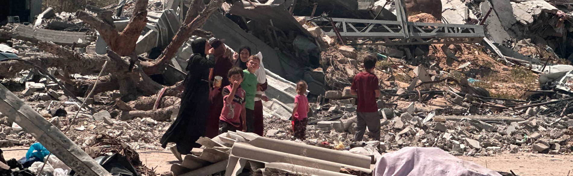 أشخاص يتواجدون وسط منطقة مدمرة في خانيونس. تصوير مكتب الأمم المتحدة لتنسيق الشؤون الإنسانية، 17 نيسان/أبريل 2024