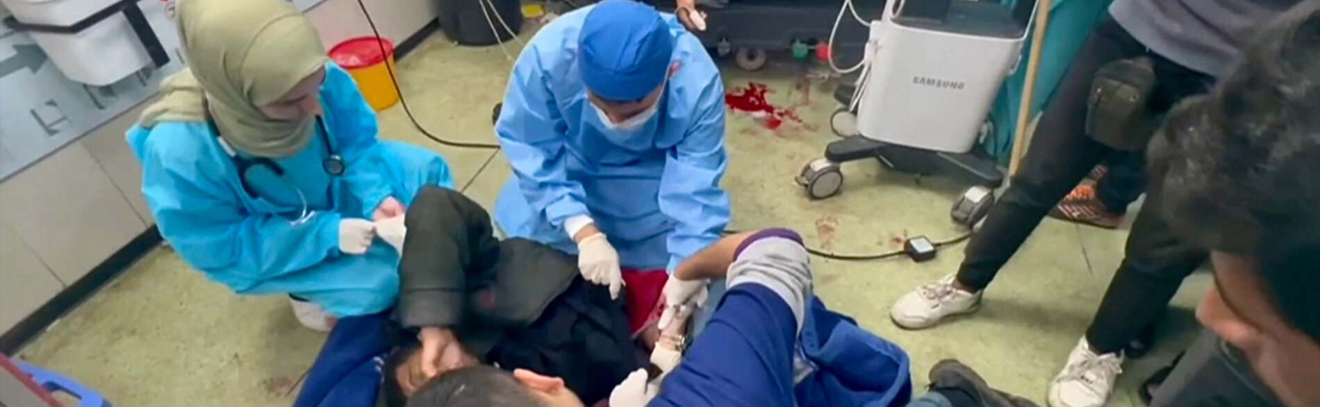צוות רפואי מטפל בנפגעי טראומה על רצפת בית החולים נאסר, ח'אן יונס. צילום מסך מתוך סרטון וידיאו של ארגון הבריאות העולמי, ינואר 2024
