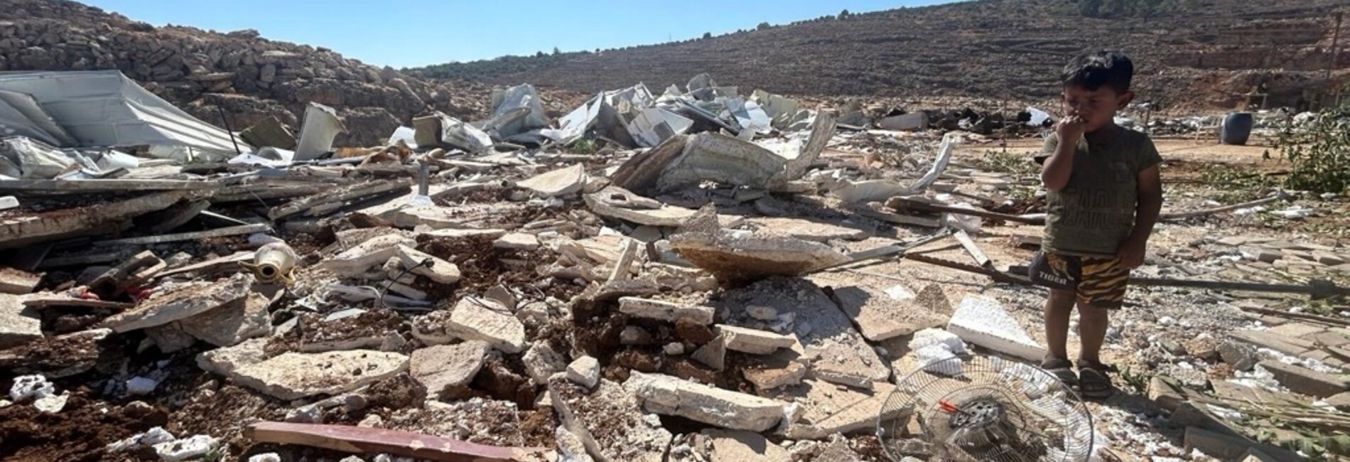 A child stands among the rubble after Israeli authorities demolished his family's home and other residential and donor-funded structures in a Bedouin community in Qalqiliya governorate on 14 July 2026. Photo: OCHA 