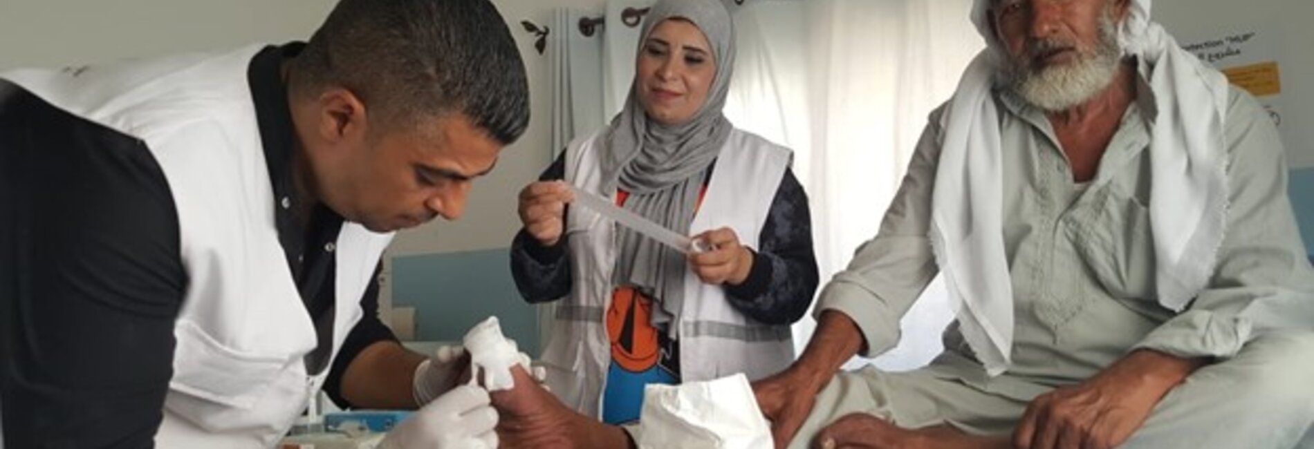 Nabil Al Amour (on the right) receiving care in a mobile clinic. Photo by Anees Mahareeq @CARE 2021