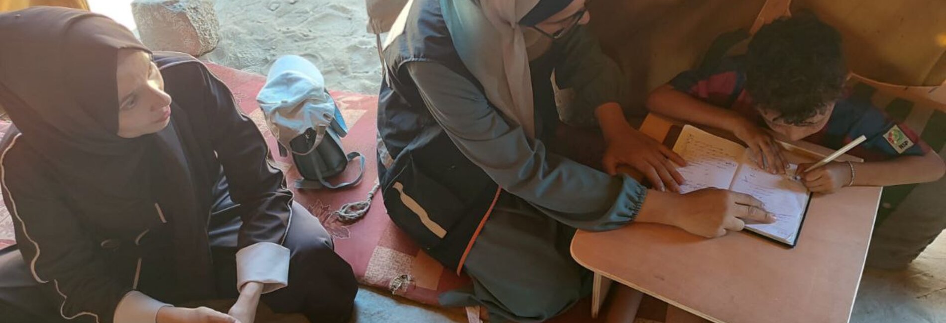 Eight-year-old Ibrahim while using his customized slant board to study, September 2025. Photo by EducAid