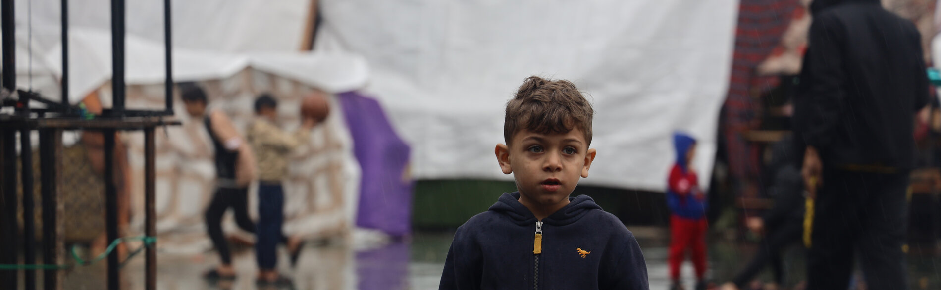 فتى مُهجّر عمره ستة أعوام في جنوب غزة، حيث زادت الأمطار الغزيرة من تفاقم الظروف المعيشية المريعة أصلًا في أوساط الأشخاص الذين يعيشون في العراء، وفاقمت من مخاطر انتشار الأمراض المنقولة بالمياه. تصوير اليونيسف/البابا، 6 كانون الأول/ديسمبر 2023