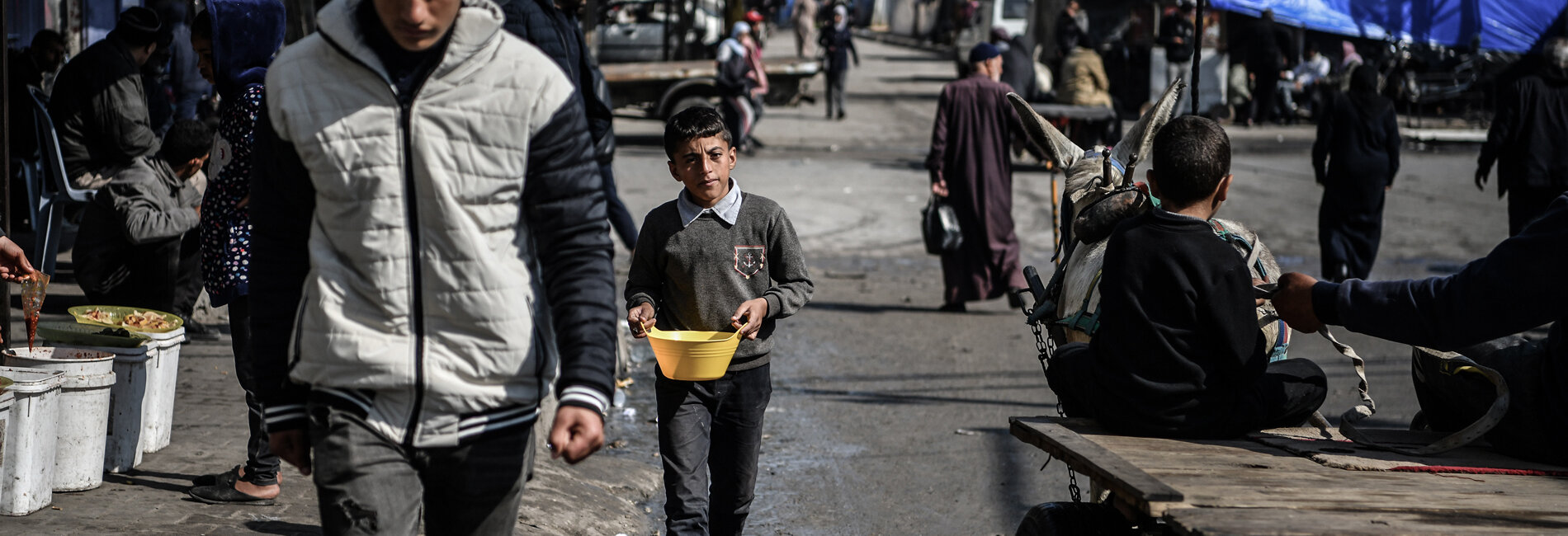 Muhammad (11) carrying a bowl of beans for his family who stay in a tent in Rafah. “Every day, I walk two kilometres and spend over five hours to provide one meal a day for my family,” he says. Photo by UNICEF/Zagout