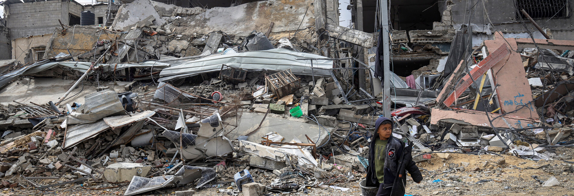 Nine-year-old Tamer walks through the rubble of his destroyed neighbourhood in Khan Younis. Photo by UNICEF/Eyad El Baba 