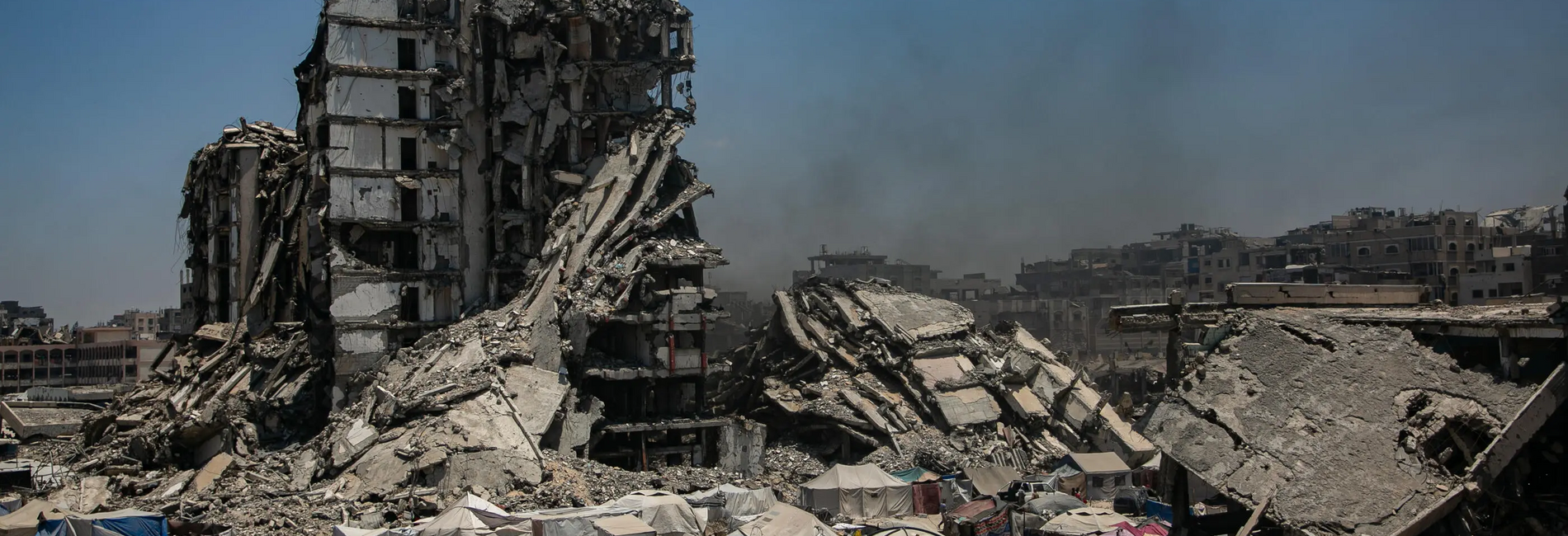 مشاهد من موقع يلتمس النازحون المأوى فيه في شمال منطقة الشاطئ، غربي مدينة غزة، حيث تعيش الأسر في ظروف قاسية وسط المباني المدمرة والأعمال القتالية المتواصلة. تصوير: اليونيسف، نتيل (UNICEF/UNI845995/Nateel)