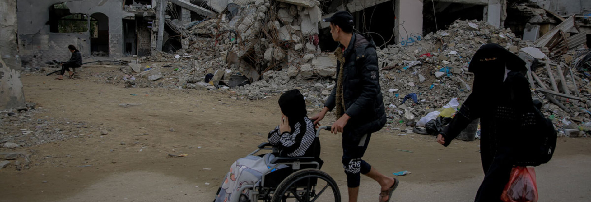 A brother and a sister passing by their destroyed home in Jabaliya, northern Gaza. Photo by UNICEF/Al-Qattaa, 7 December 2023 