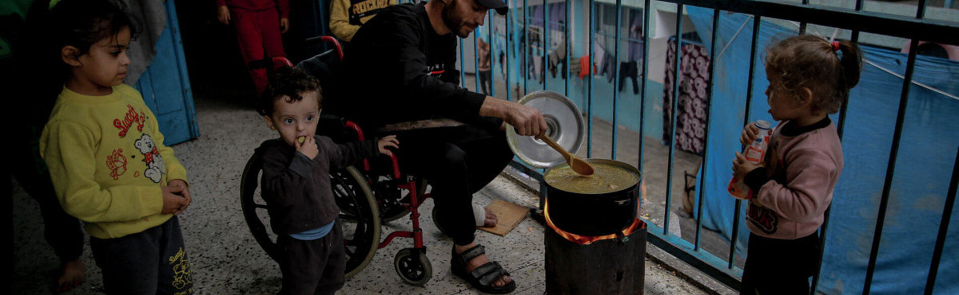 Gaza grapples with catastrophic hunger as new report predicts famine if conflict continues. A displaced Palestinian man cooking food on wood fire due to gas shortages in the schools where he takes shelter with his family. Photo by UNICEF/Omar Al-Qattaa, 7 December 2023