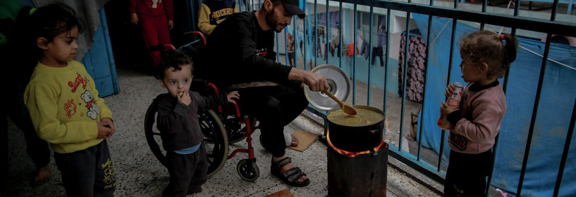 Gaza grapples with catastrophic hunger as new report predicts famine if conflict continues. A displaced Palestinian man cooking food on wood fire due to gas shortages in the schools where he takes shelter with his family. Photo by UNICEF/Omar Al-Qattaa, 7 December 2023