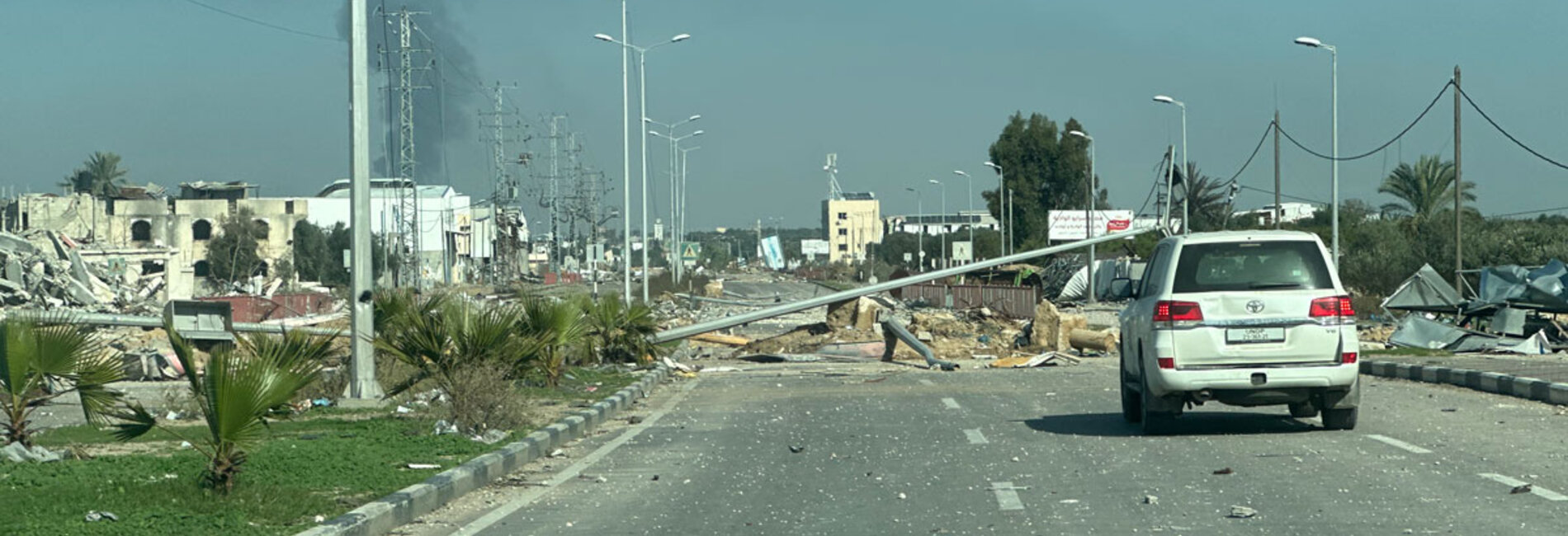 Damaged roads and intense hostilities are among the challenges faced by humanitarian workers struggling to support people in need across Gaza. A United Nations car driving on a damaged road in Deir al Balah. Photo by OCHA/Olga Cherevko, 18 January 2024 