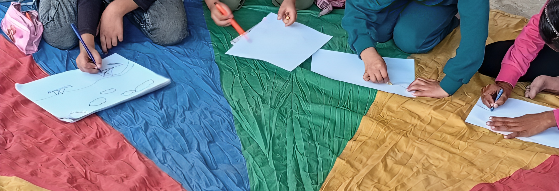 Tala and other children drawing in a temporary learning space in 2025. Photo by NRC. 