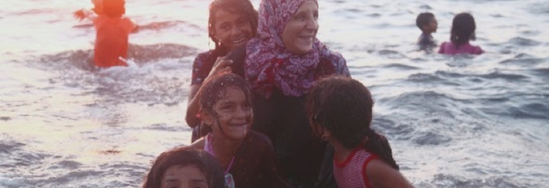 Ahlam joining her children in swimming at the beach.  Dear Al Balah Camp. © Photo Credit: Rehaf Batniji/OXFAM 2018