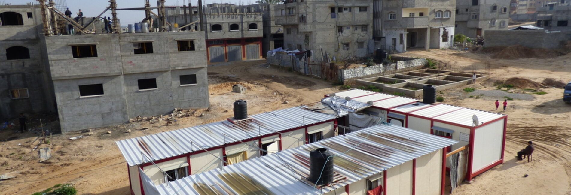 Caravans provided to displaced families and buildings under reconstruction in Shuja’iyeh neighbourhood, Gaza city, January 2016. © Photo by OCHA