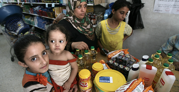 משפחה פלסטינית קונה מוצרי היגיינה בחנות המשתתפת בתוכנית השוברים האלקטרוניים של יוניצ״ף – תוכנית המזון העולמית © צילום: תוכנית המזון העולמית / קולין קמפשר