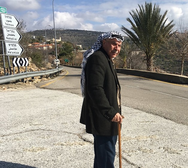 עבאס יוסף עומד על כביש שהגישה אליו מוגבלת, המוביל אל טלמון, דצמבר 2016 / © צילום: משרד האו״ם לתיאום עניינים הומניטריים