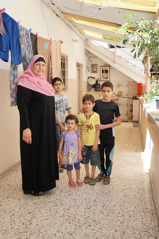 Siham al Tatari with her grandchildren outside her house in Gaza, June 2017. ©  Photo by OCHA.