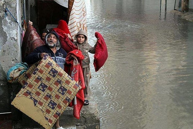 Family evacuating their home in Gaza, 12 December 2013