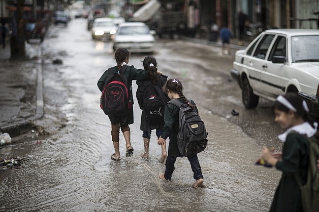 ילדים חוזרים מבית הספר בזמן הצפות בעיר עזה, ינואר 2015 / © צילום: ויסאם נאסר