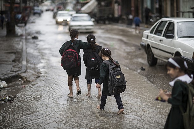 Children on their way back from school, during floods in Gaza city, January 2015. © Photo by Wissam Nassar