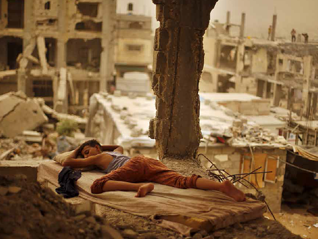 Palestinian boy sleeping inside his destroyed home in the Shuja’iyeh neighbourhood of Gaza City, September 2015. Photo by Suhaib Salem