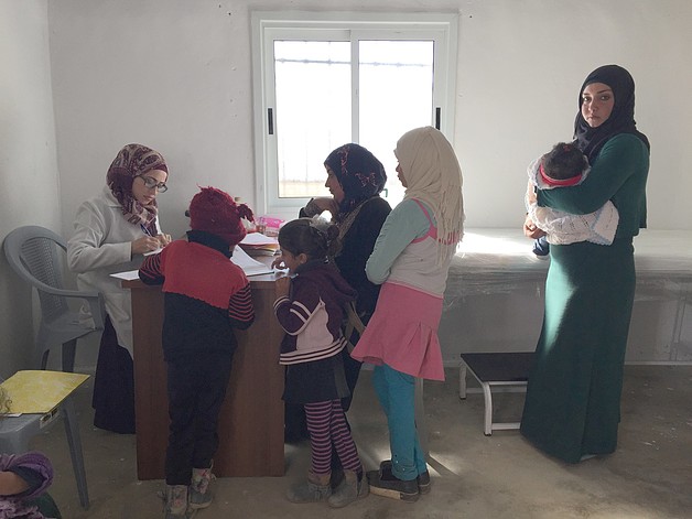 Amal and her sister-in-law and their children receiving treatment at al Mirkez mobile clinic. Photo by OCHA