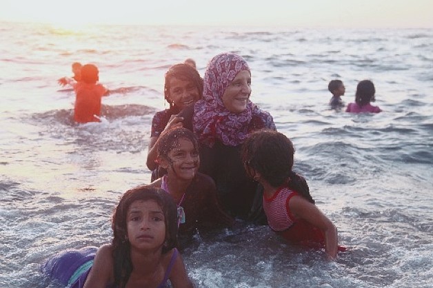 أحلام مع أطفالها وهم يسبحون على الشاطئ، مخيم دير البلح للاجئين © - تصوير رهف بطنيجي، منظمة أوكسفام، 2018