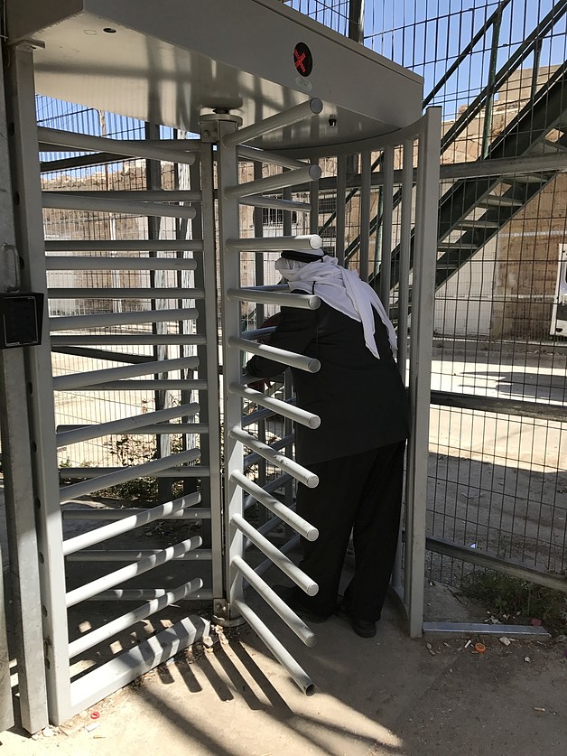 Old Palestinian man accessing Abu Ar Rish Checkpoint in H2 area of Hebron City. 28 August 2017. © Photo by OCHA. 