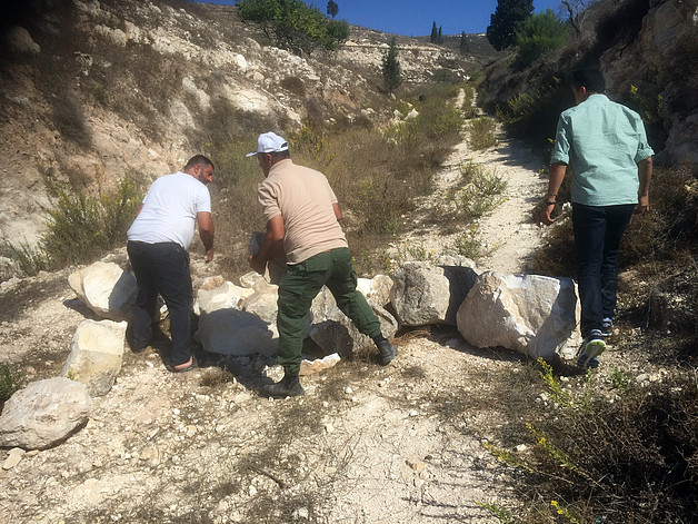 Farmers from Burqa as they remove stones which settler used to block the road to their land, Burqa, October 2017. © Photo by OCHA