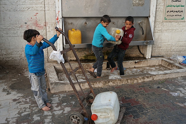 Children collecting water from a desalination point in Ash Shati Refugee Camp, Gaza, February 2017. ©  Photo by OCHA.