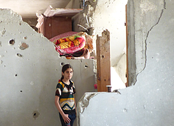 سرة أبو القمبوس تعمل إصالحات مؤقتة لمنزلها الذي تضرر بشكل كبير في الشجاعية صورة بواسطة مكتب تنسيق الشؤون اإلنسانية