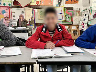 Mohammed sitting in his classroom in As Sawiya al Lubban Secondary School. © Photo by OCHA