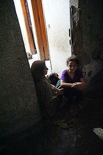 Abeer al Nemnem and her daughters sitting at the porch of their house in Ash Shati Refugee Camp, Gaza, May 2017. ©  Photo by OCHA.