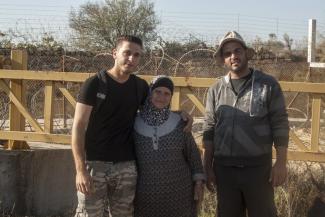 Hiyam Ahmad Jumaa, and her two sons in front of “Barrier Gate 105”, outside of Beit Surik village (Ramallah), 31 October, 2019. ©  Photo by OCHA