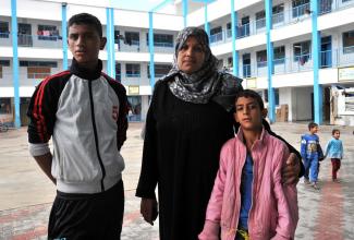 Afaf and two of her nine children at the UNRWA Collective Centre. Photo by UNRWA