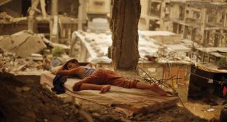 Palestinian boy sleeping inside his destroyed home in the Shuja’iyeh neighbourhood of Gaza City, September 2015. Photo by Suhaib Salem