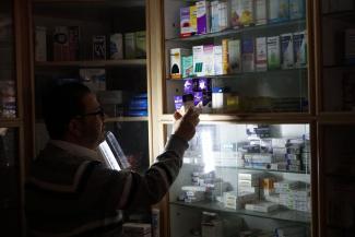 Pharmacist using emergency light, Gaza 27 April 2017. © Photo by OCHA.