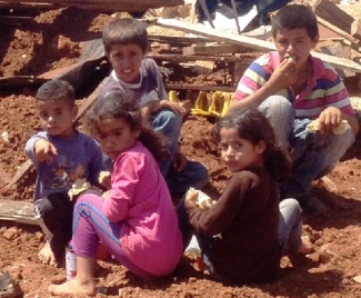 Palestinian refugee children from East Tayba Bedouin community, following the demolition of their home, 20 August 2014. Photo by OCHA