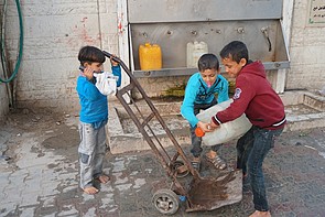 Children filling water gallons from distribution point in the Beach refugee camp 2017. © Photo by OCHA Children filling water gallons from distribution point in the Beach refugee camp 2017. © Photo by OCHA